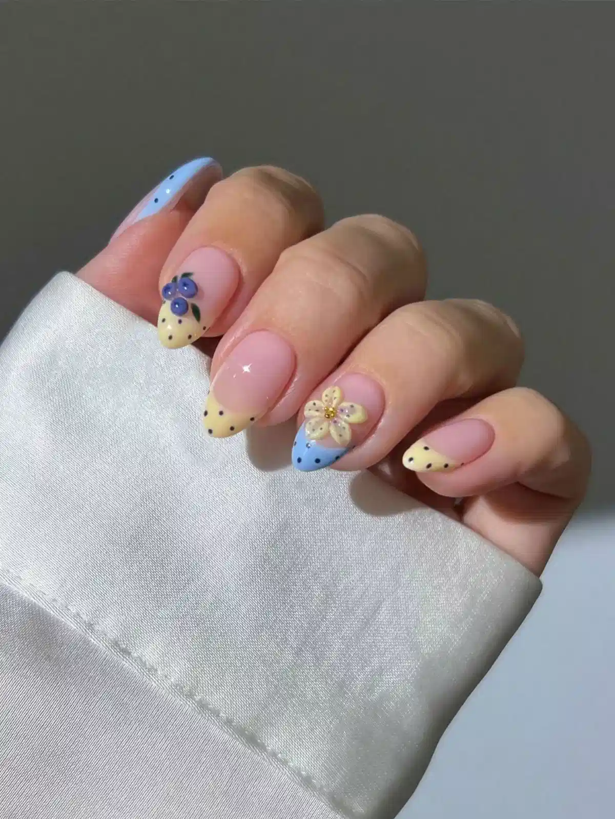 Mixed-color French tips with dots, florals, and berry accents