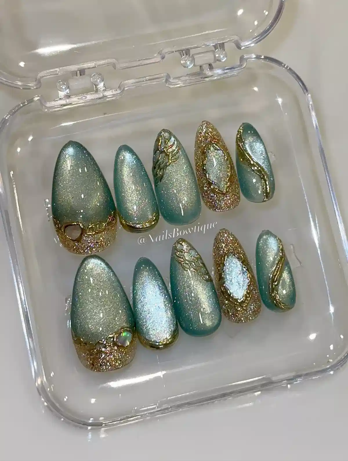 Teal shimmer nails with gold glitter borders and raised gold veining