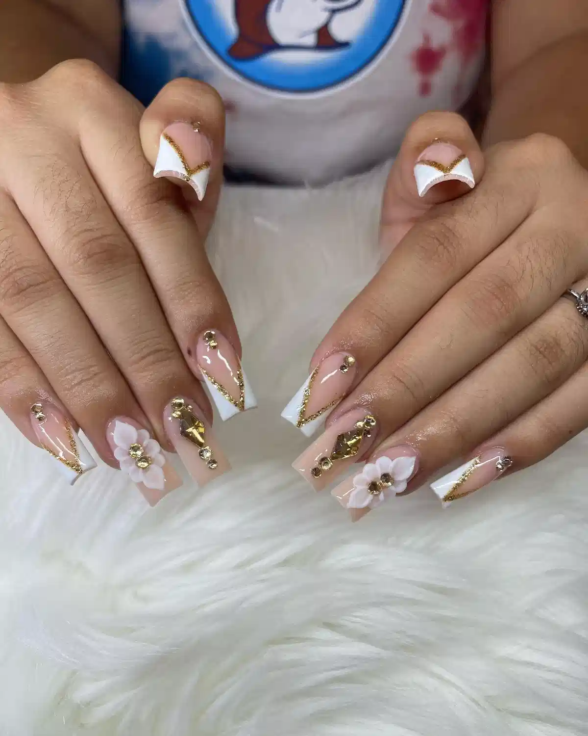 Long square French tips with gold glitter V-lines and 3D flowers