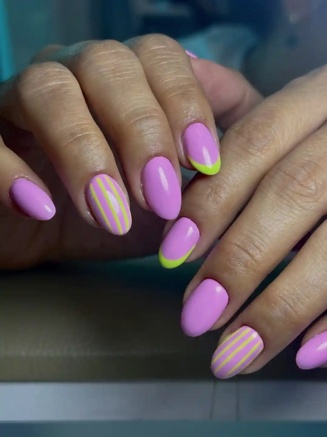 Pink-lavender nails with neon yellow-green tips and stripes