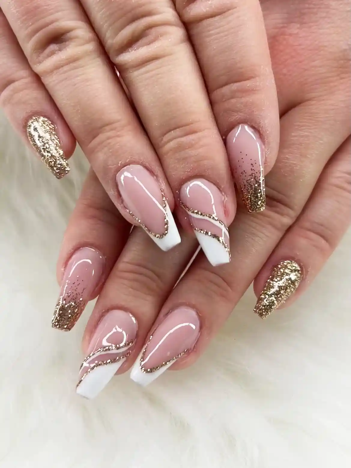 White French tips with gold glitter swirls and full glitter accents