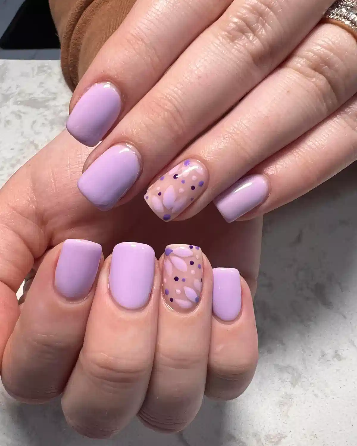 Glossy pastel lavender squares with confetti-and-leaf accent nails
