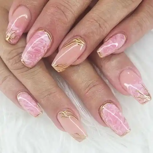 Square light-pink nails with gold edging and subtle marbling