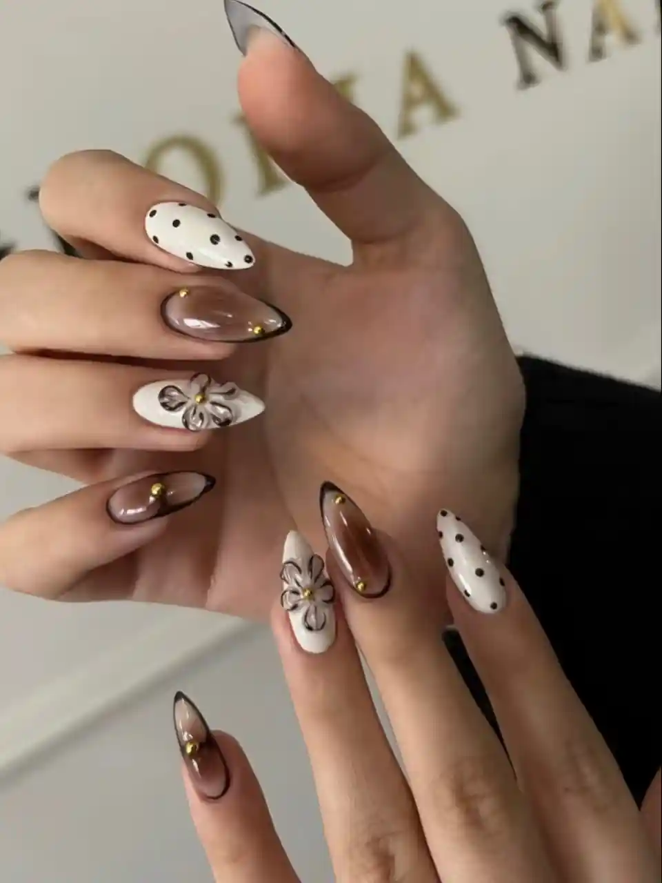 Polka dots and brown-outlined nails with floral accents