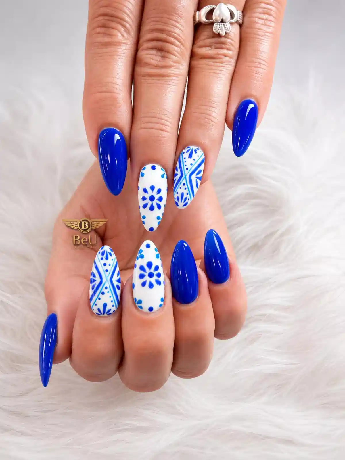 Royal blue solids with white-and-blue patterned accent nails