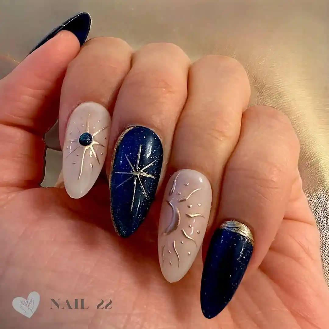 Navy glitter-look nails with starburst art and nude textured accents