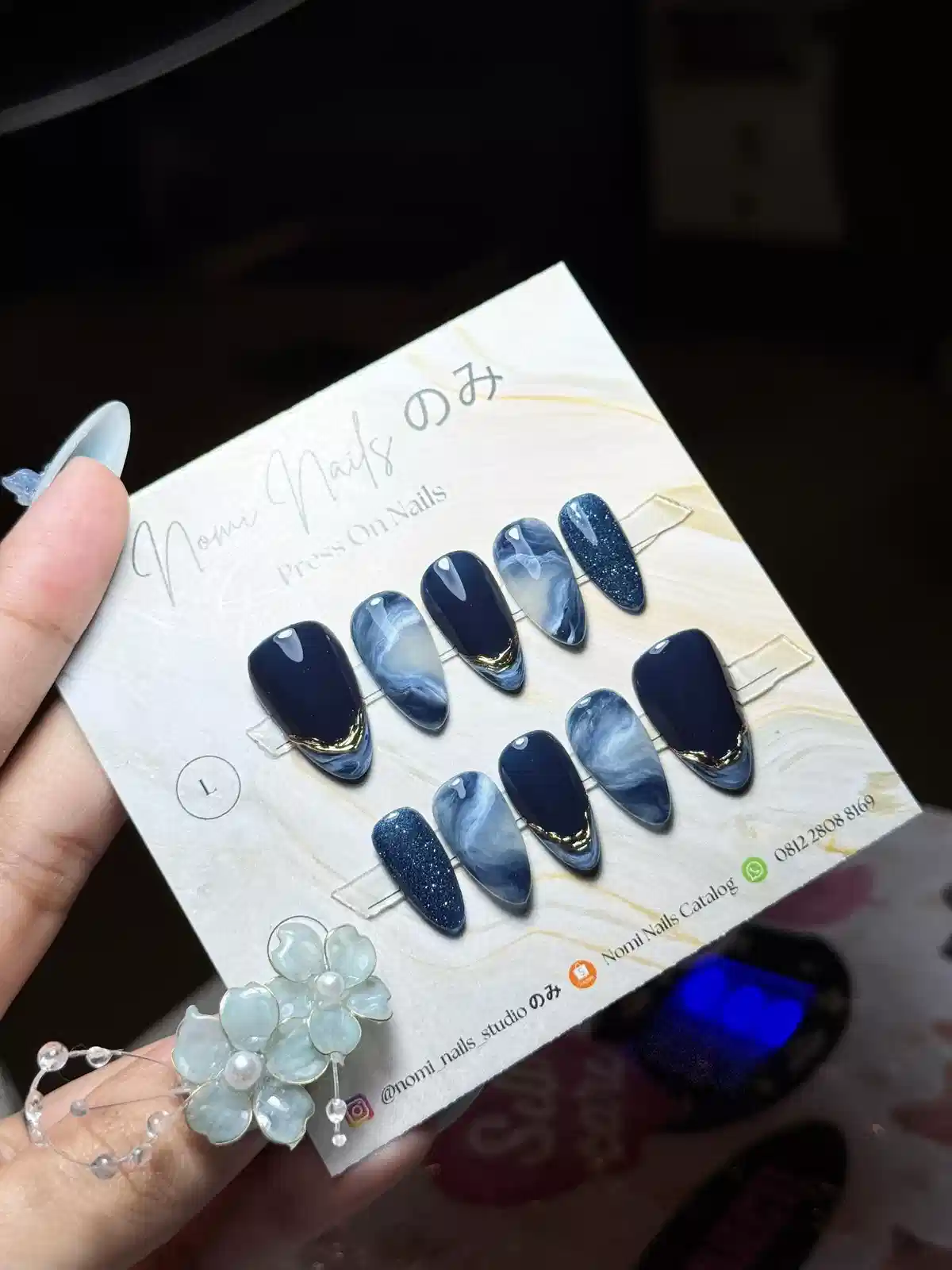 Dark navy and marbled blue press-ons with thin gold tip accents