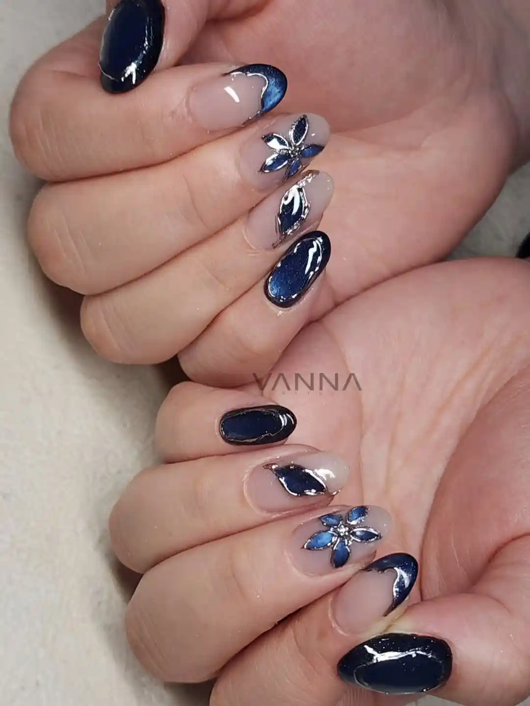 Navy-and-nude glossy nails with metallic outlines and 3D flowers