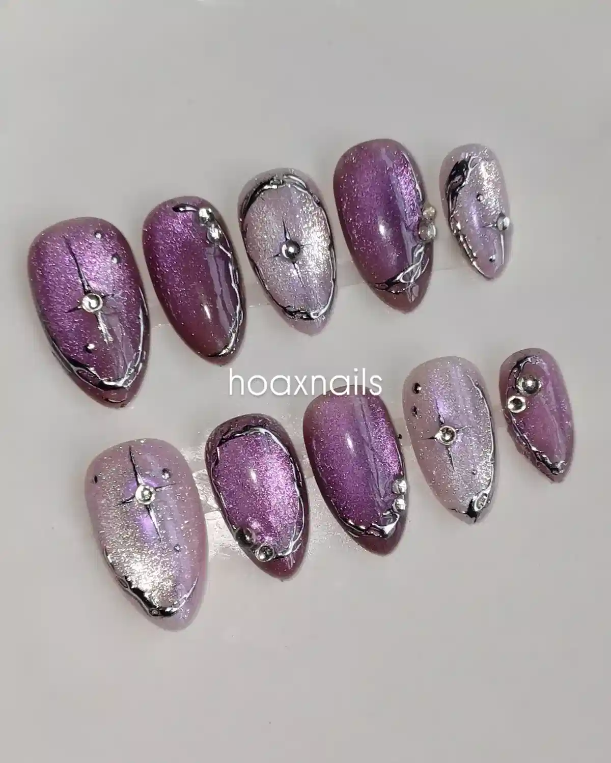 Purple and silver glitter nails with raised metallic outlines