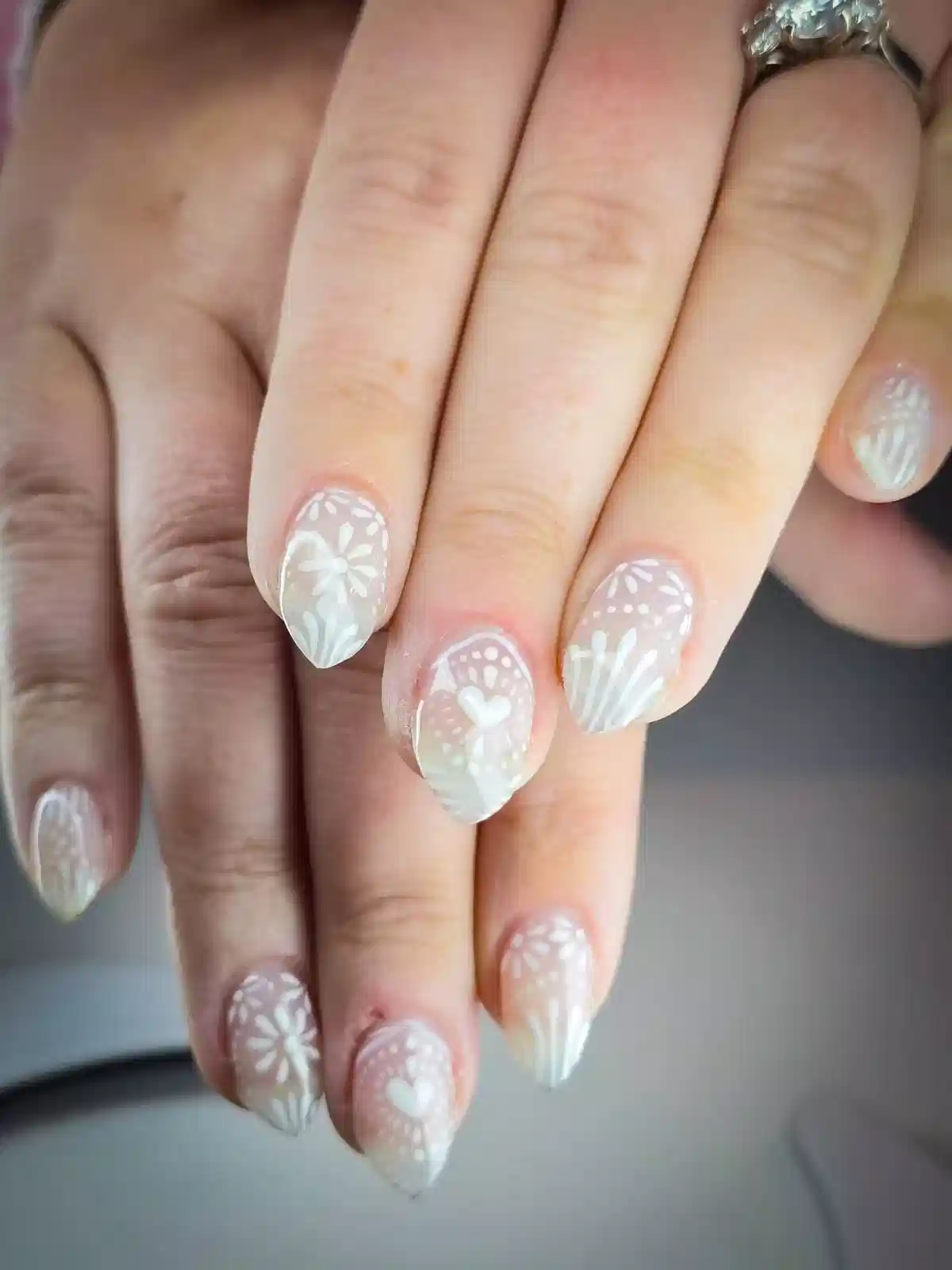 Sheer nude nails with white lace florals and small hearts