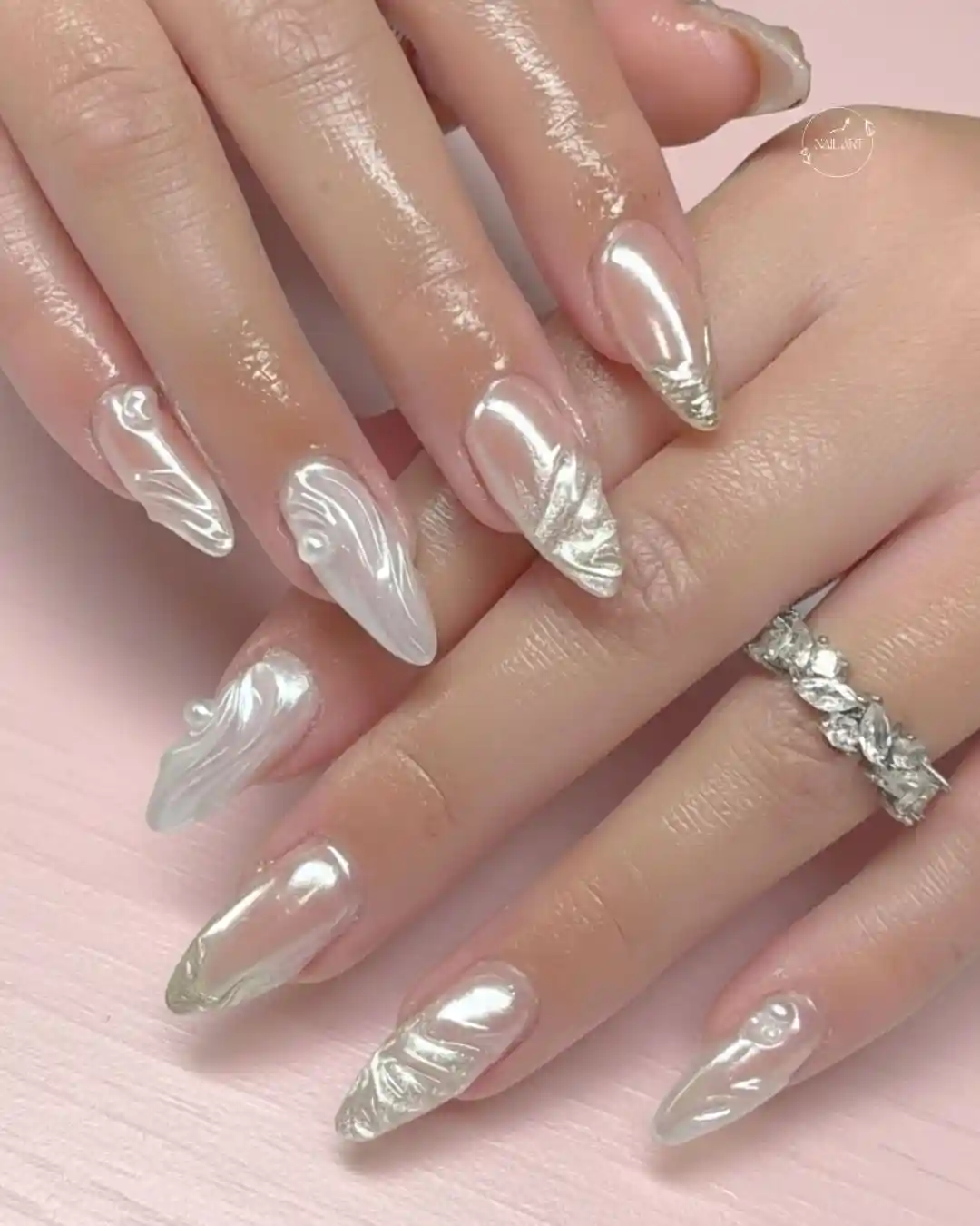 Reflective silver nails with raised white swirl accents