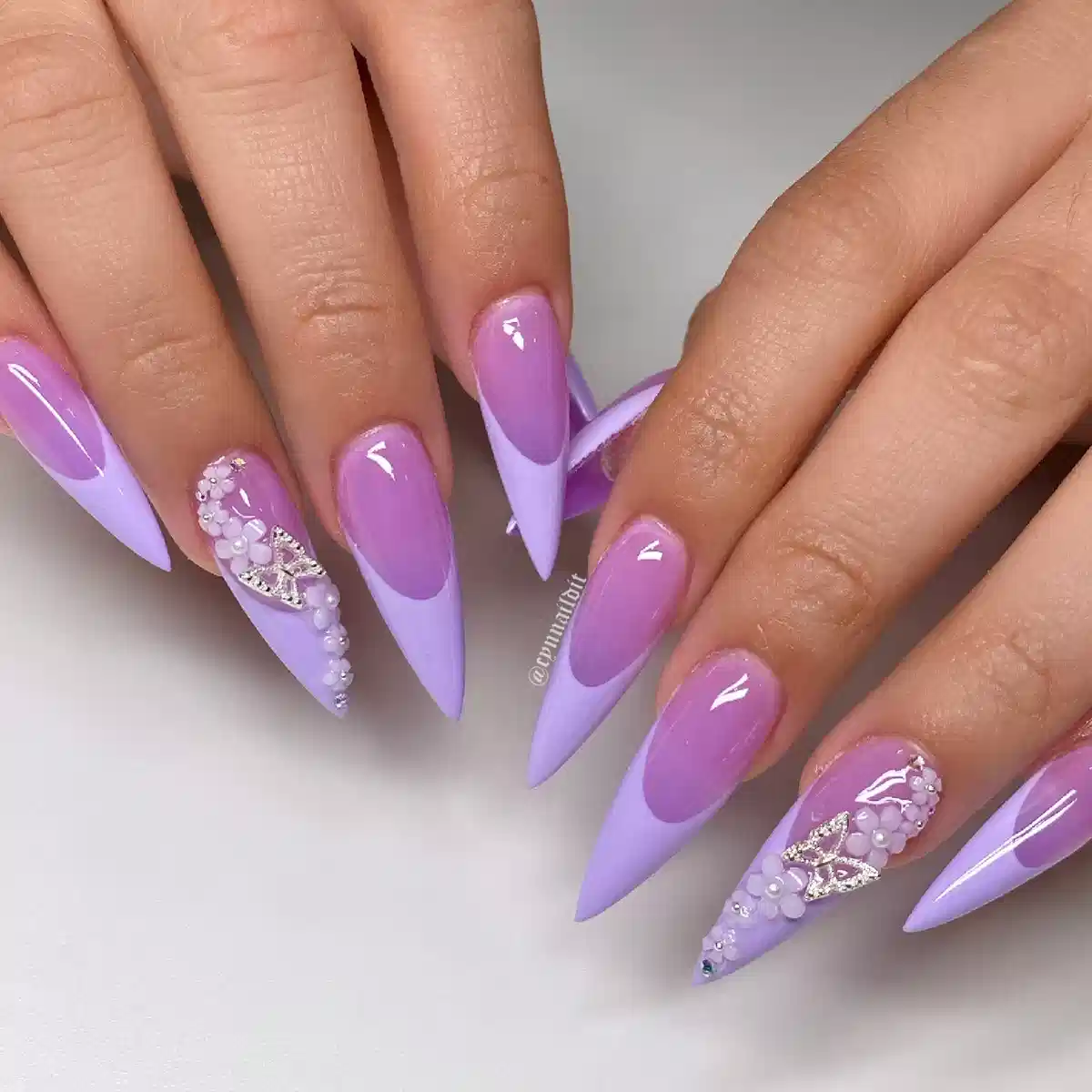Two-tone lavender stiletto nails with rhinestone-and-bead clusters