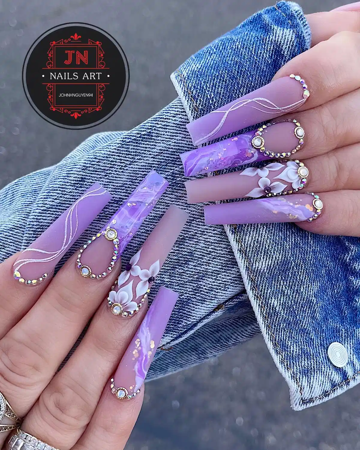 Purple marble coffin nails with rhinestone outlines and 3D flowers