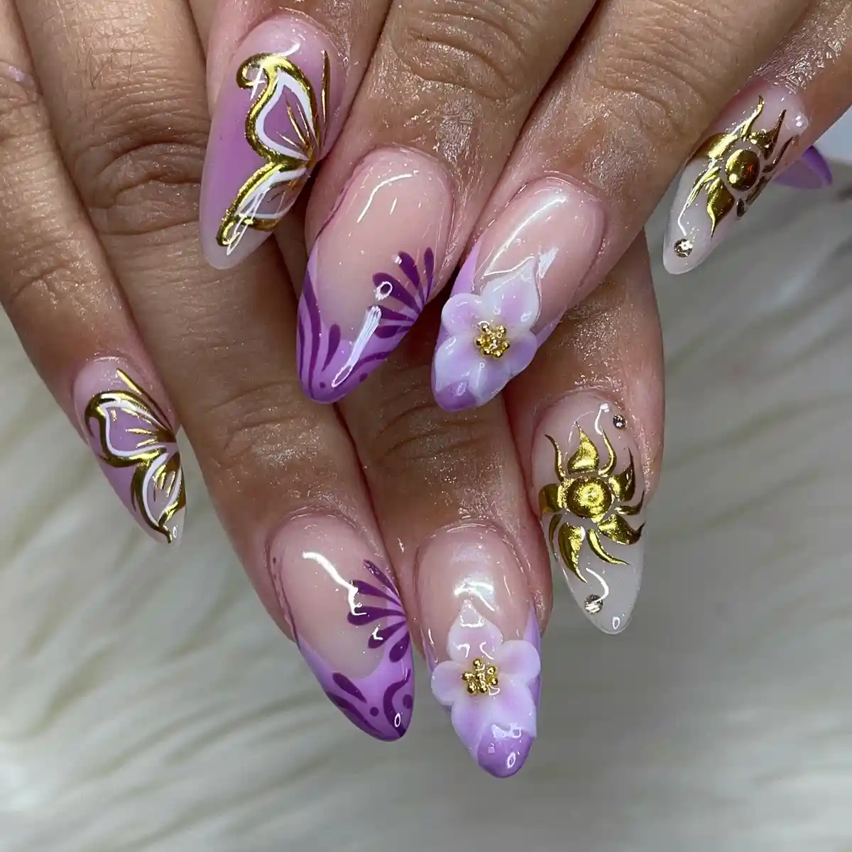 Purple graphic almond nails with 3D flowers and gold insect motifs