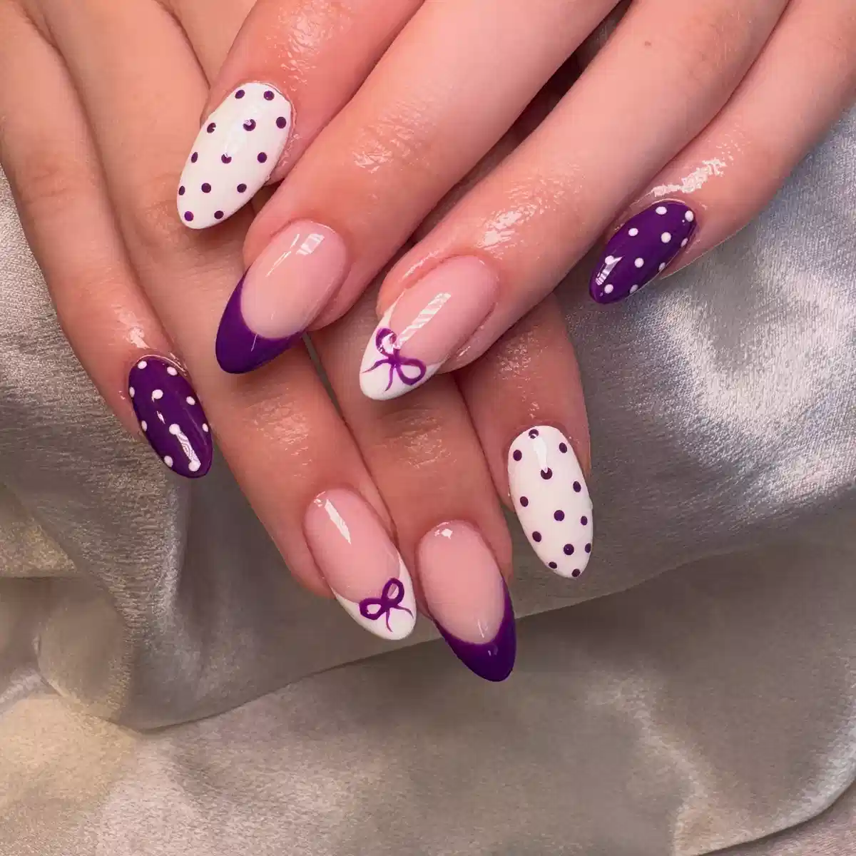 Purple French tips with polka dots and bow accents