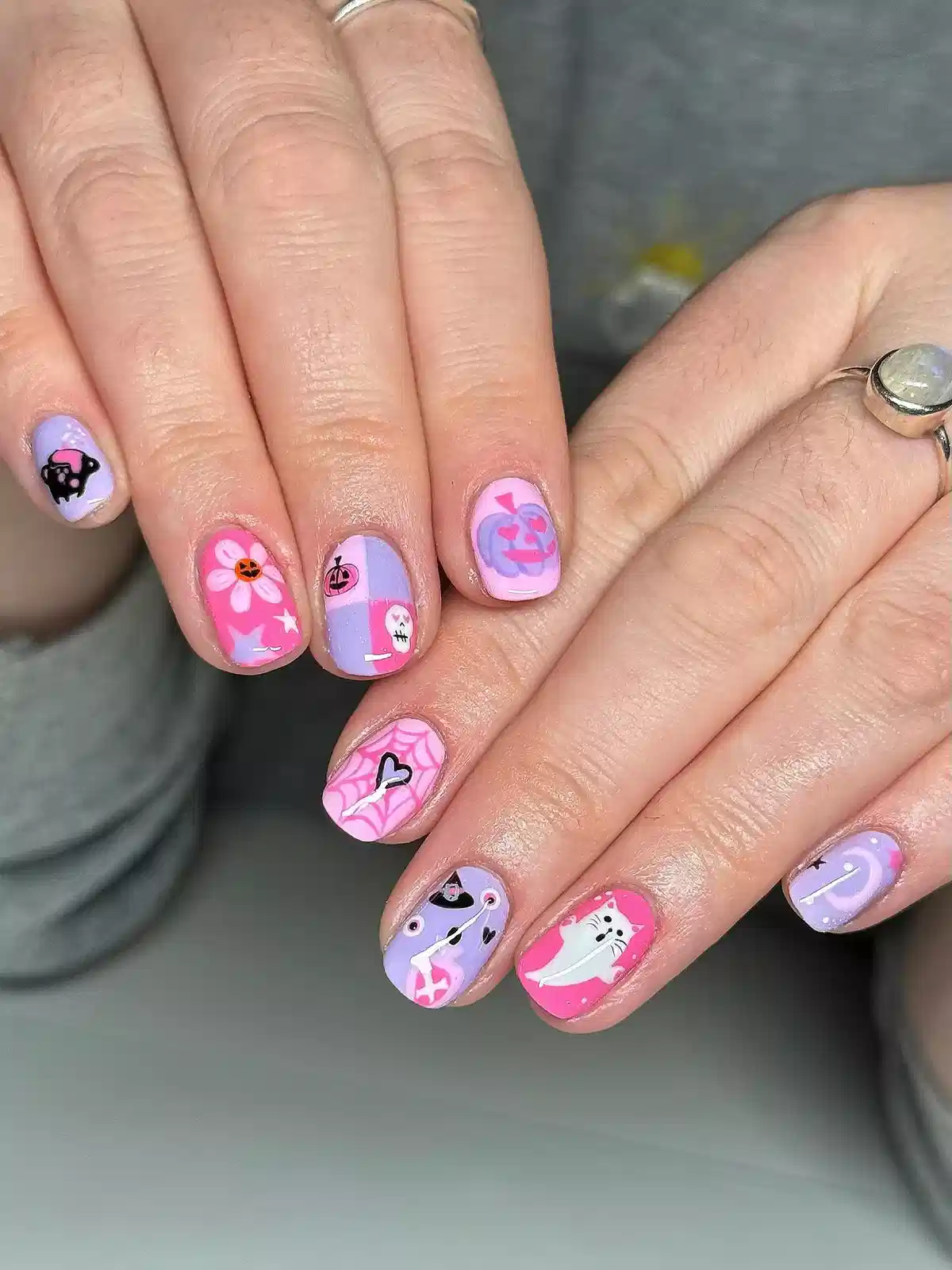 Pink and lavender character nails with webs and pumpkins