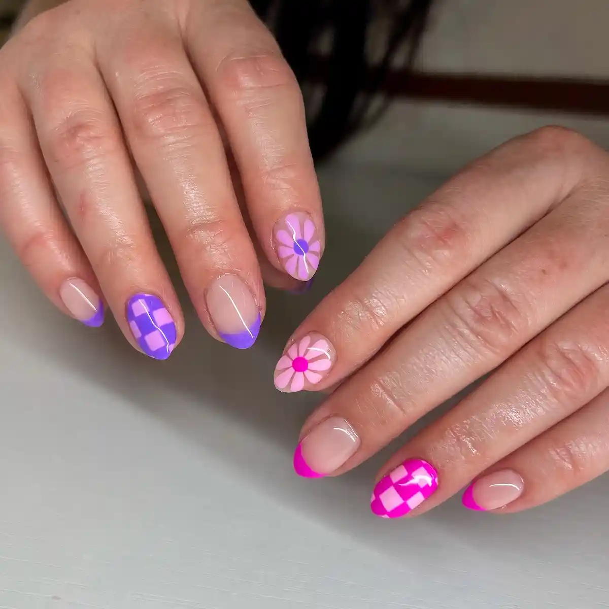 Nude French tips with pink/purple checks and daisy accents