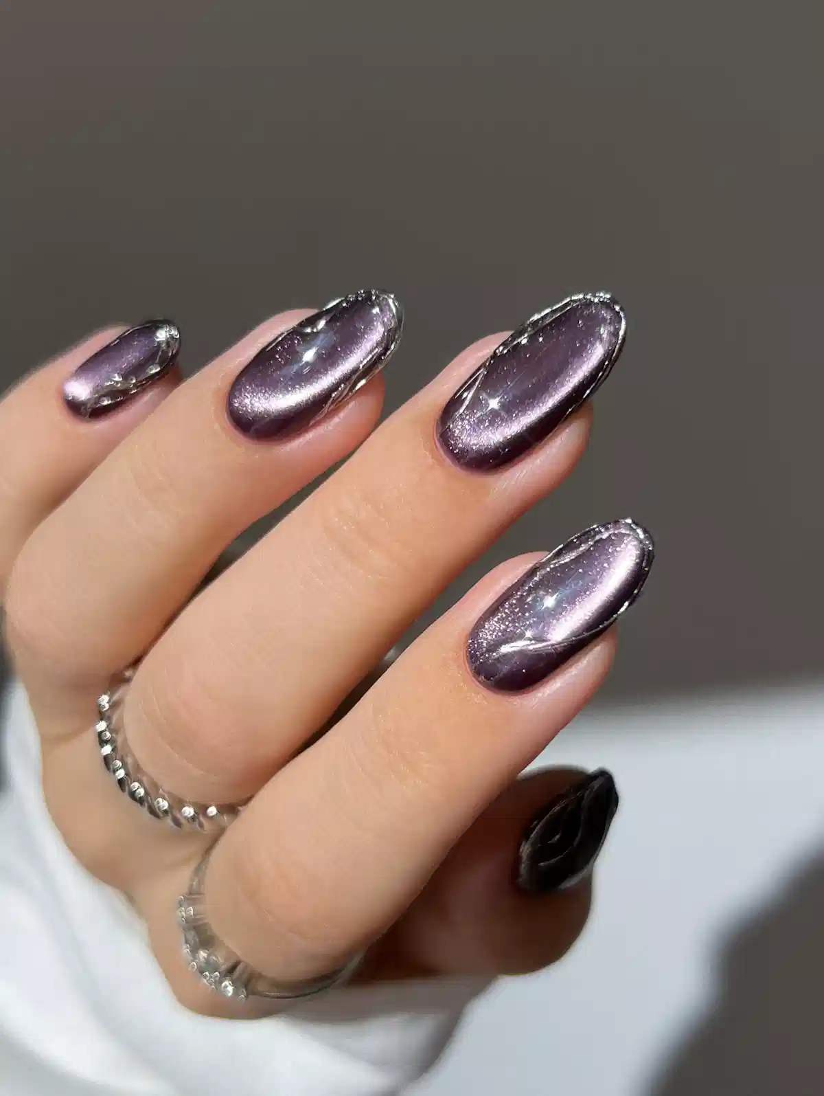 Metallic mauve-purple nails with silver glitter outline edging