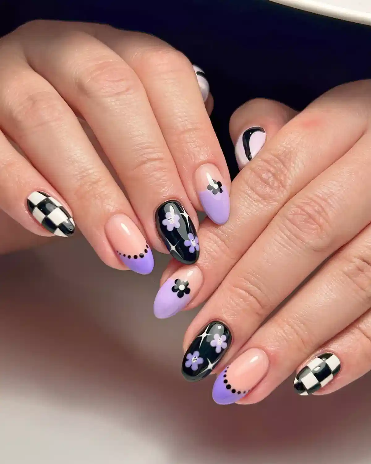 Lavender tips with checkerboard and black floral accent nails
