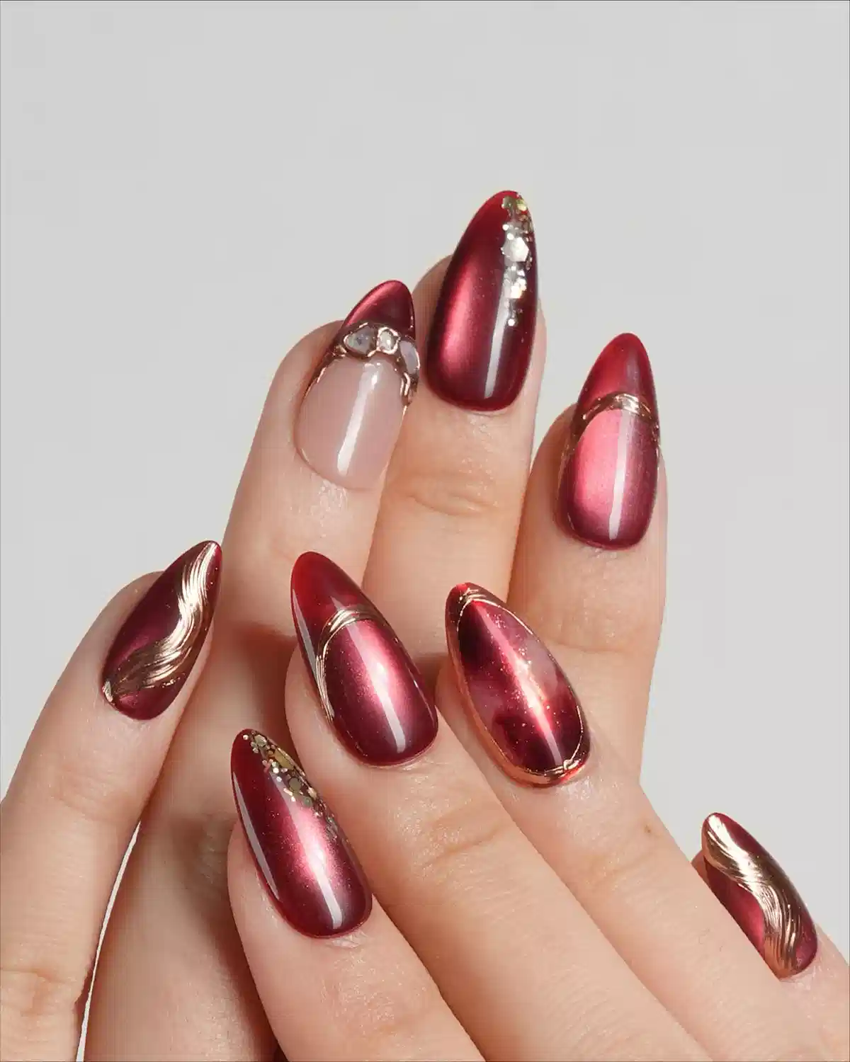 Metallic red gradient nails with gold line accents