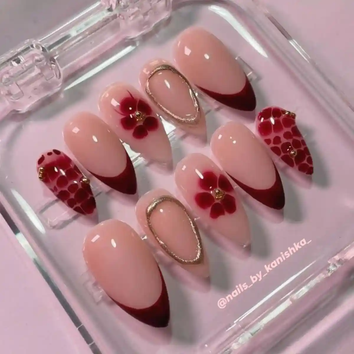 Nude-and-red French tips with floral and spotted accent nails