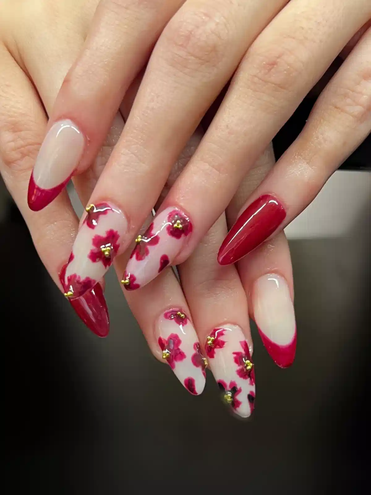 Red French tips with floral patterned accent nails