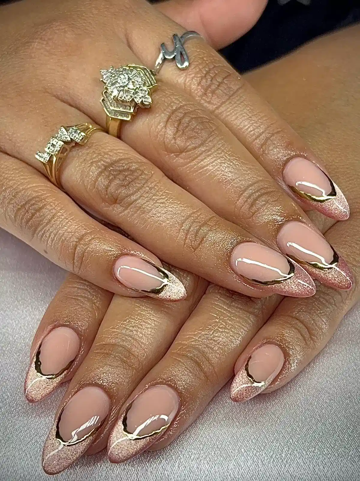 Nude-to-rose glitter tips with curved gold detailing