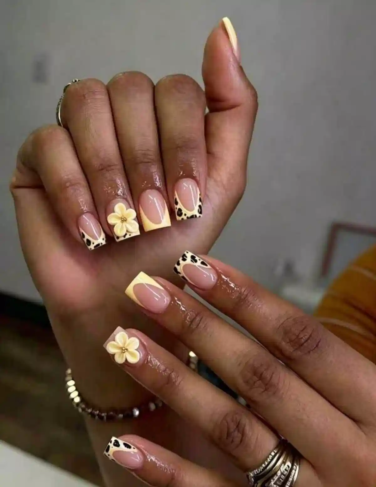 Yellow French tips with black spot pattern and 3D flower accents
