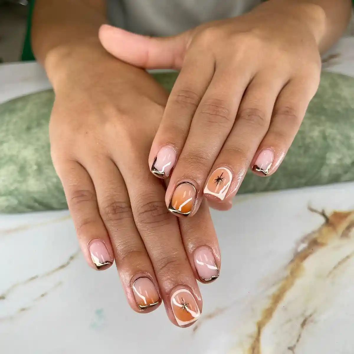Nude bases with gold-edged tips and starburst accents