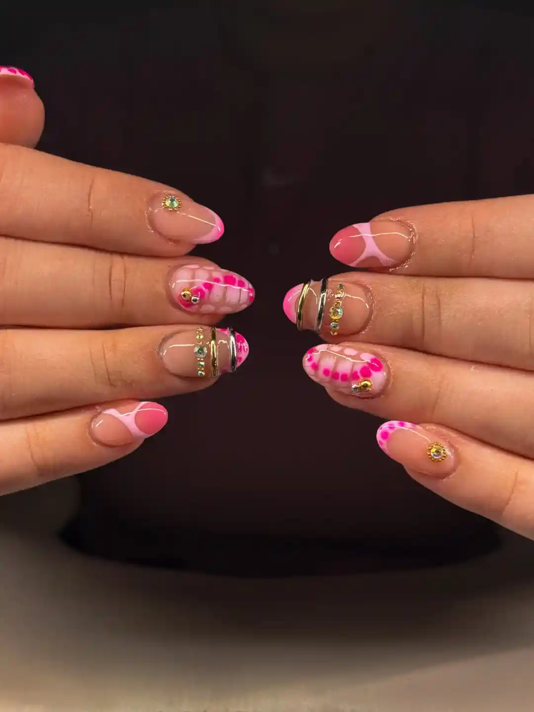 Bright pink French tips with grid-and-dot accents and rhinestones