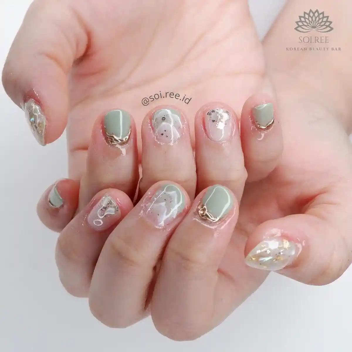 Sage green tips with gold edging and clear shimmer accents