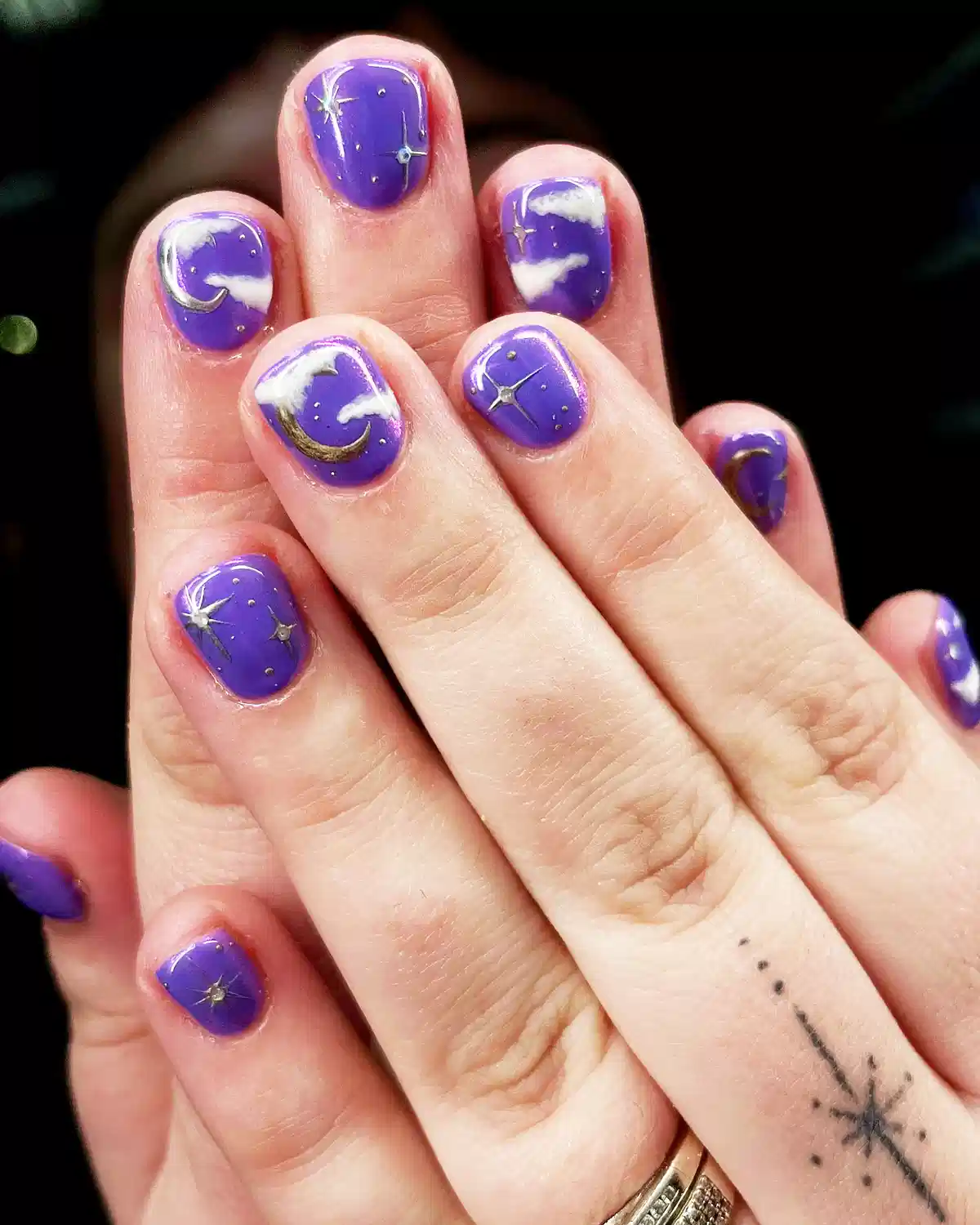 Purple sky nails with clouds, moons, and stars