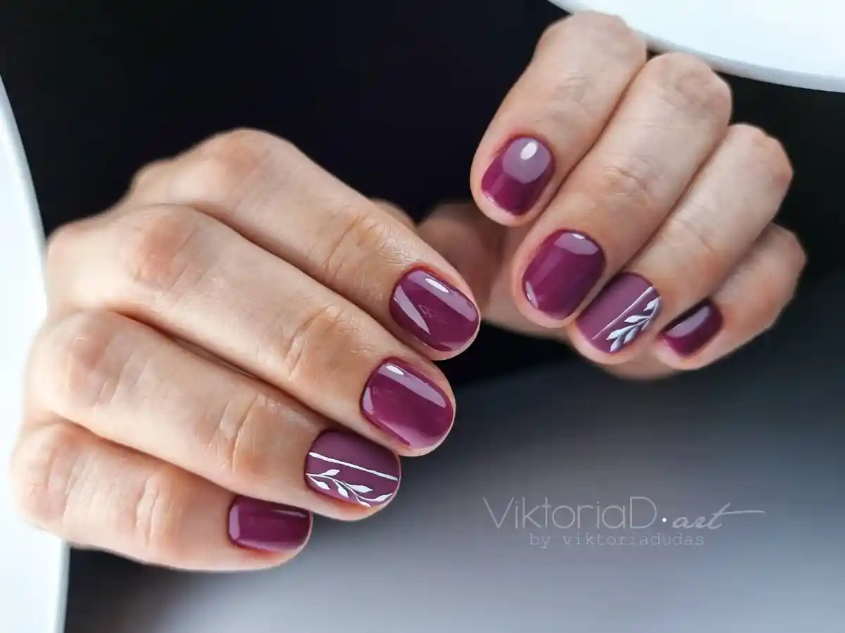Deep plum nails with white leaf line art