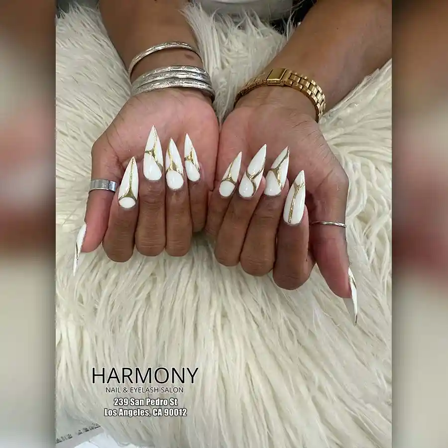 White stiletto nails with gold striping