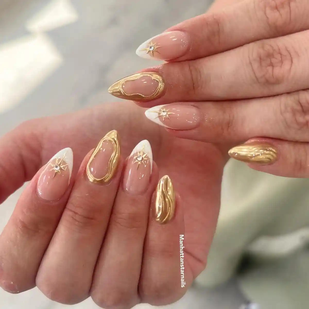 Gold starbursts and metallic accents on nude French tips